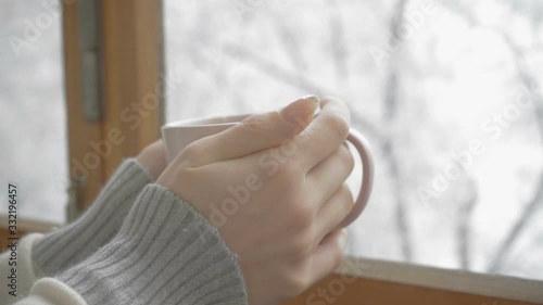 Wallpaper Mural Hands of a girl with a cup of coffee on a background of forest and snowfall Torontodigital.ca