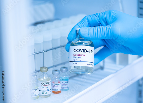 Doctor's hand holding bottle vaccine to patient in storage box.Vaccination against coronavirus quarantine or covid-19.Protection against virus and infection control.Medication treatment concept.