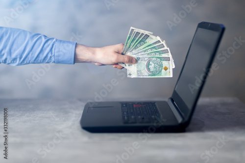 Bizmesmen trzymający gotówkę przy komputerze. Koncepcja zarabiania online