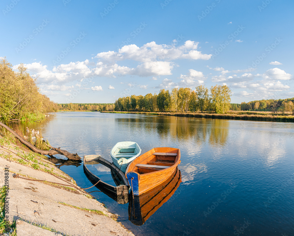 Three boats on the bank of the river. Summer landscape. Ural, Russia