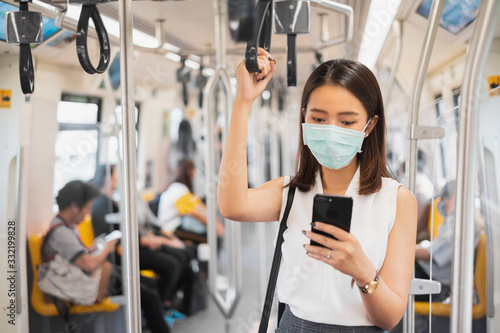Coronavirus(Covid-19) concept, Asian woman wearing protective face mask to protect infection from coronavirus covid-19 standing at sky train and crowd people