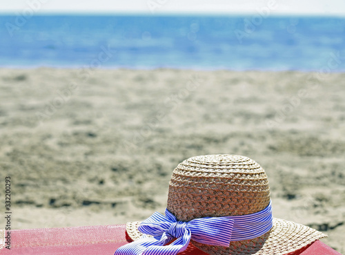 straw hat above the beach bed by the sea in summer