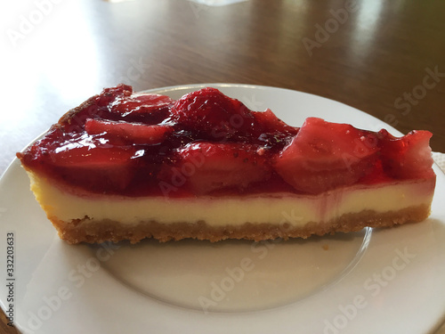 Obraz na płótnie Slice of cheesecake with strawberries on a white plate. w salonie