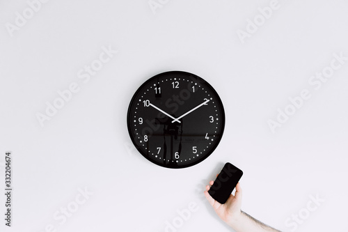  clock on white wall with one smartphone 