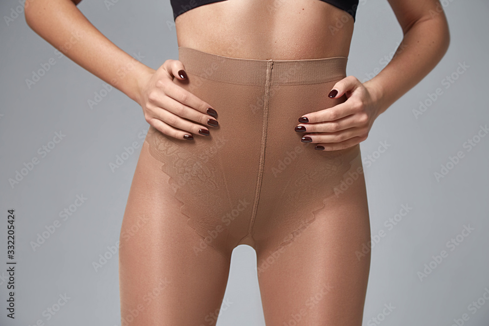 Part of woman body perfect shape hips legs skin tan wear stockings, nylons,  pantyhose lingerie hosiery hose studio shot on white background. Stock  Photo