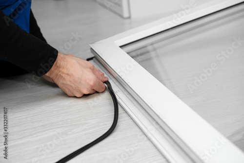 Foto Professional master at repair and installation of windows, changes rubber seal g