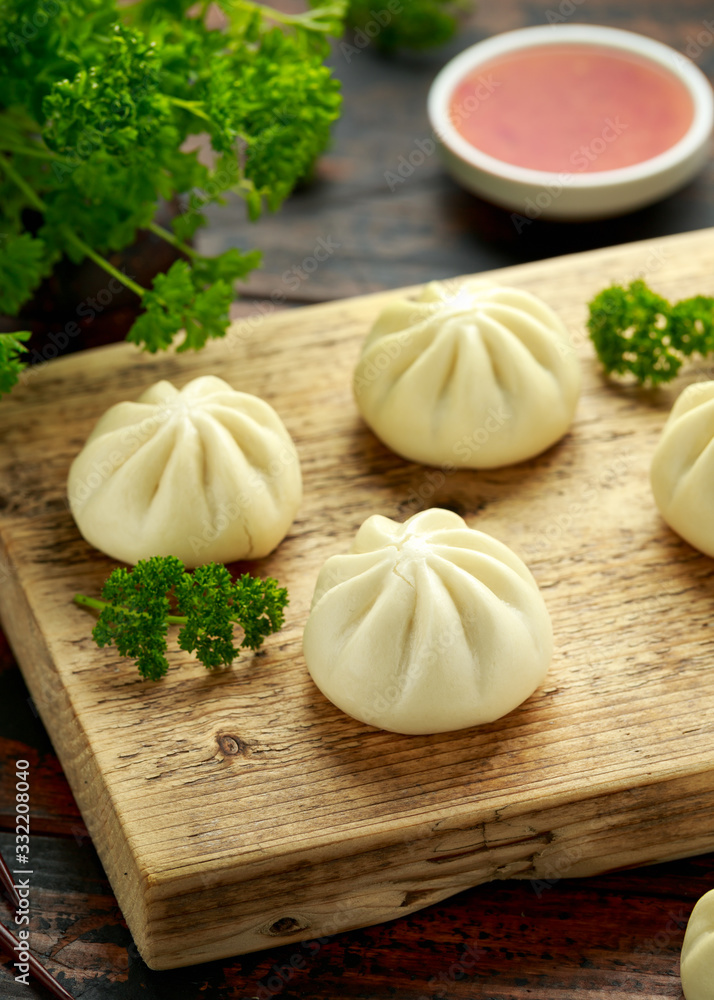 Steamed Buns with duck stuffing, chili sauce on wooden board. Asian food. Steamed Buns with duck stuffing, chili sauce on wooden board. Asian food.