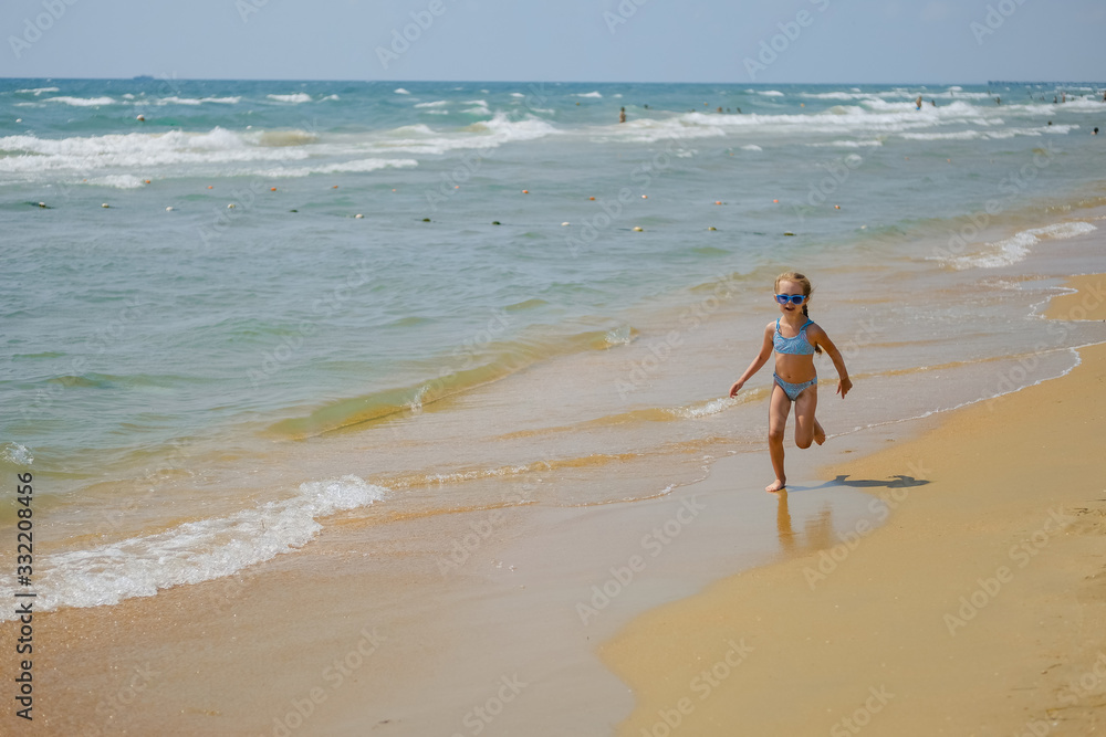 Child in sunglasses on the ocean. Little girl on the beach. Child in sunglasses on the ocean. Little girl on the beach.