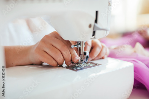 seamstress puts on a white thread in a sewing machine. Presser foot close-up