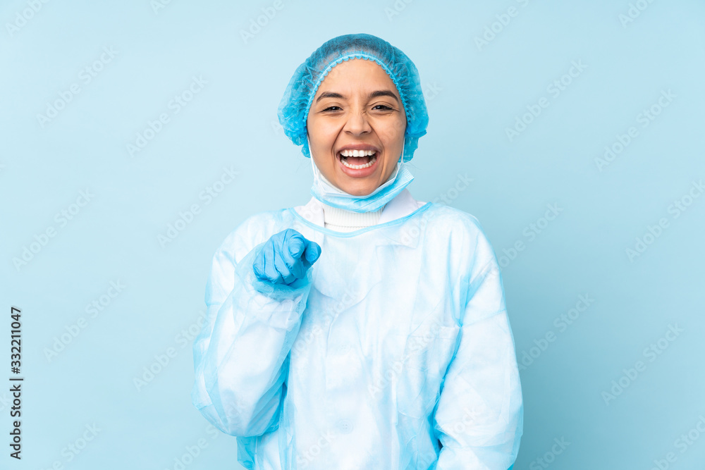 Young surgeon Indian woman in blue uniform surprised and pointing front Young surgeon Indian woman in blue uniform surprised and pointing front