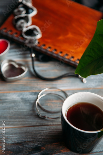 flatlay style girls stuff black neklace rings and notebook with pen and bag and cup of tea photo