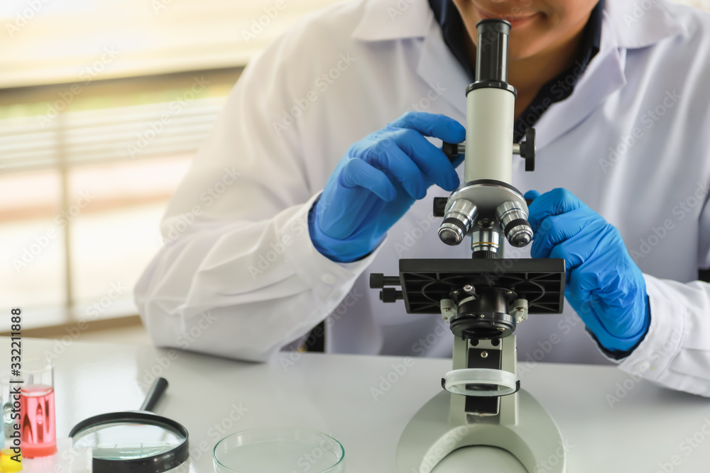 Portrait of professional young doctor scientist using microscope and research in working laboratory. Science and Healh Care Concept. Portrait of professional young doctor scientist using microscope and research in working laboratory. Science and Healh Care Concept.