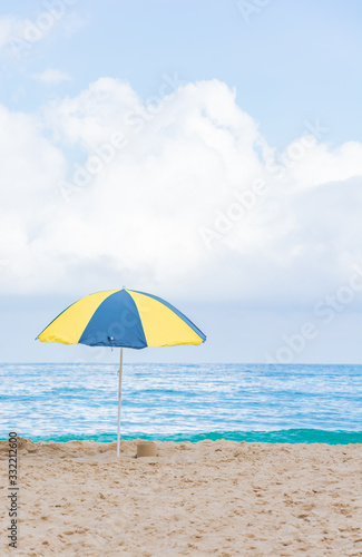 Beach umbrella in beautiful scenery with sand  blue sea and cloudy sky in Trindade  Paraty  Brazil.