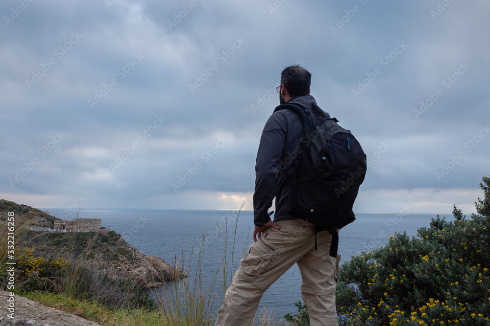 Standing man observing the landscape on a cloudy morning