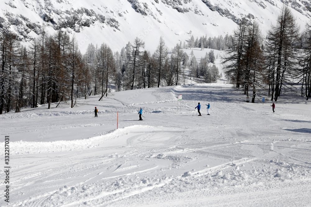 Top view of the skier, which descends skiing down from the slope. People racing sky snowboards on piste. Friends sport travel extreme leisure on winter christmas holidays. Top view of the skier, which descends skiing down from the slope. People racing sky snowboards on piste. Friends sport travel extreme leisure on winter christmas holidays.