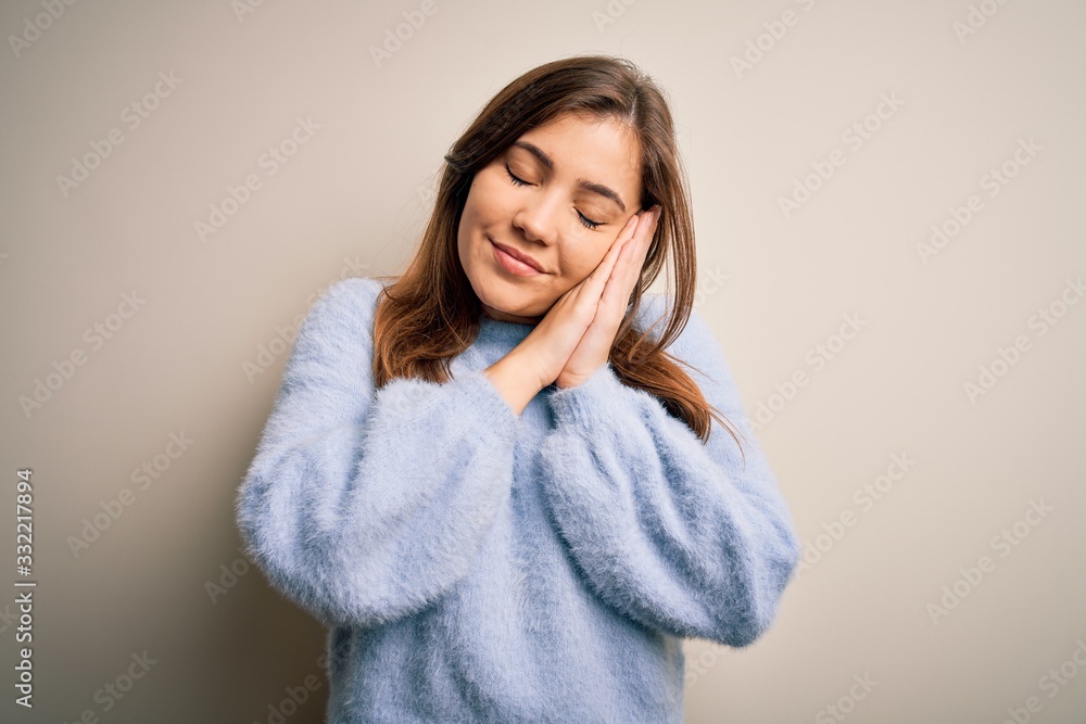 Beautiful young woman wearing casual winter sweater standing over isolated background sleeping tired dreaming and posing with hands together while smiling with closed eyes. Beautiful young woman wearing casual winter sweater standing over isolated background sleeping tired dreaming and posing with hands together while smiling with closed eyes.