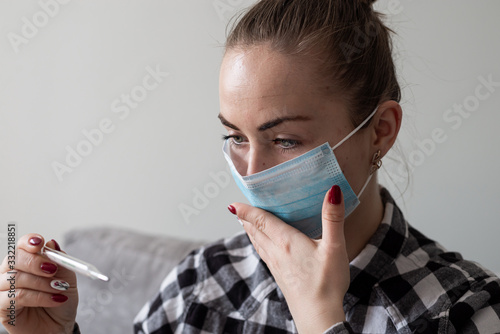 Girl with medical mask to protect her from virus. Coronavirus pandemic. Woman with mask standing . People being hospitalized, diagnosed, often put in carantine (isolation) to stop spreading Corona. photo