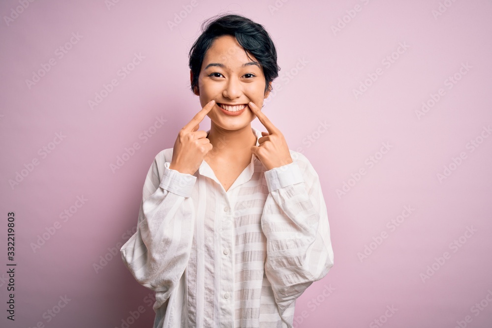 Young beautiful asian girl wearing casual shirt standing over isolated pink background Smiling with open mouth, fingers pointing and forcing cheerful smile Young beautiful asian girl wearing casual shirt standing over isolated pink background Smiling with open mouth, fingers pointing and forcing cheerful smile