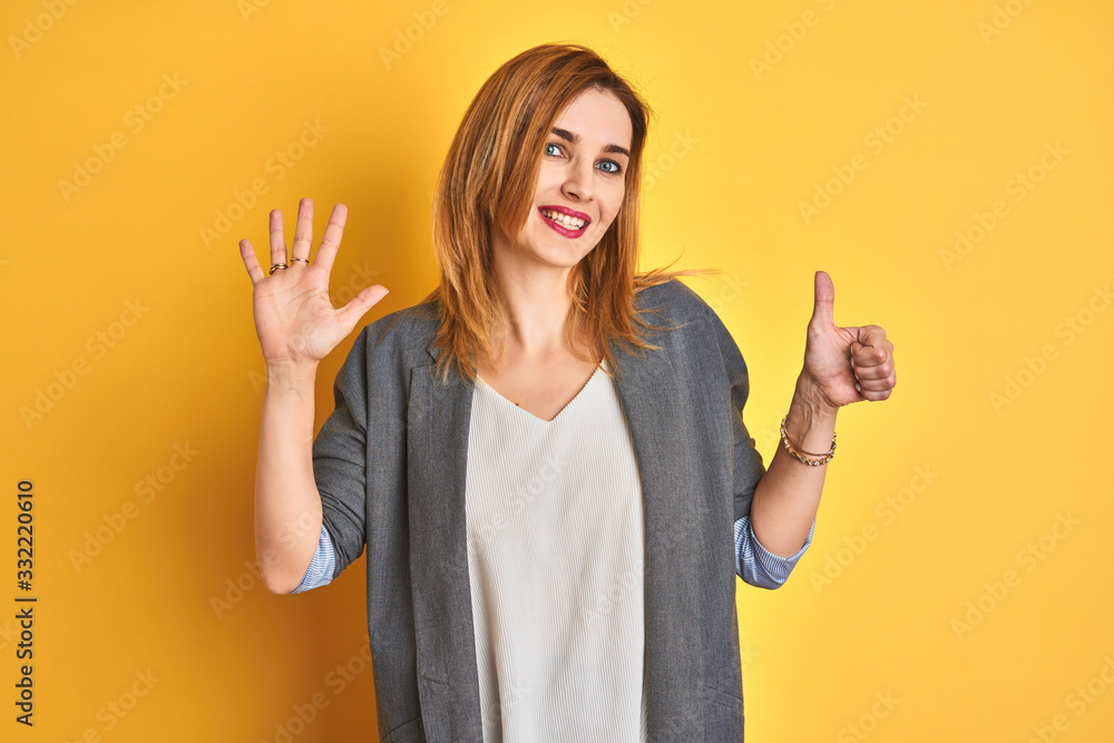 Redhead caucasian business woman over yellow isolated background showing and pointing up with fingers number six while smiling confident and happy.