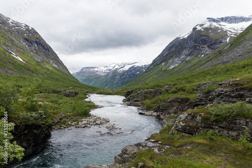 river that runs between high mountains of Norway during the summer