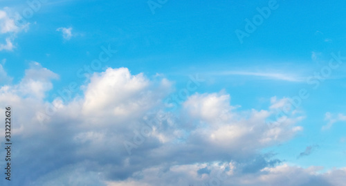 Light blue sky with white sun clouds_