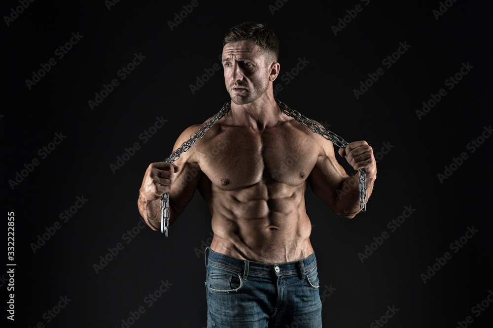 Intensity builds immensity. Athlete with metal chain black background. Strong athlete with six pack abs. Handsome athlete shirtless in jeans. Athlete or bodybuilder with fit torso. Fitness and sport