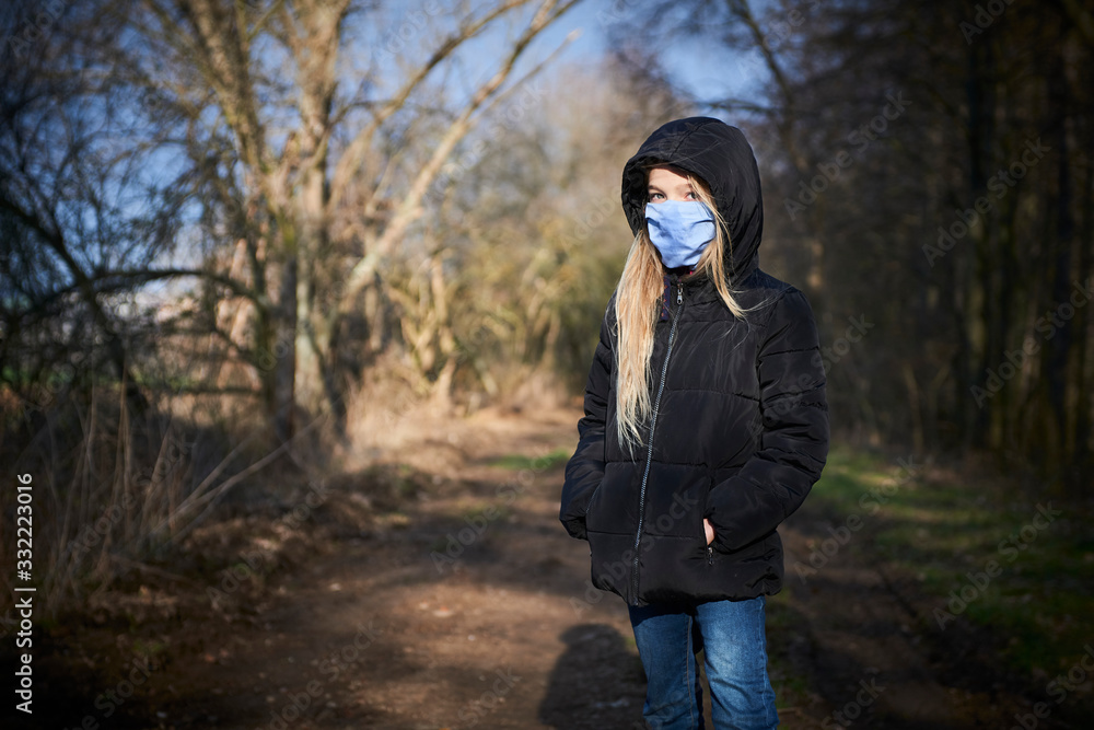 Fototapeta premium Child girl on medical walk during pandemic of Coronavirus disease (COVID-19). It is very important to go out during quarantine with a protective mask