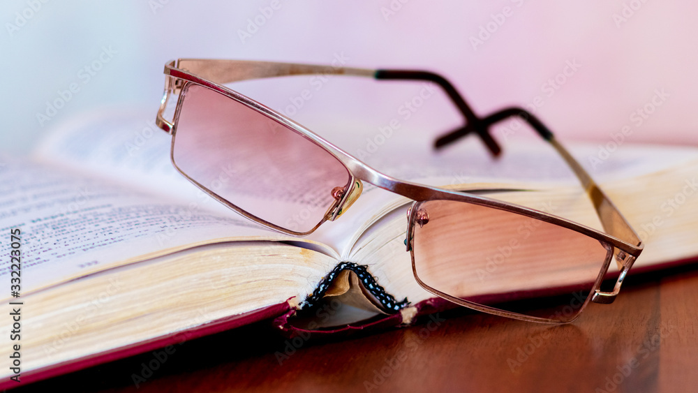Glasses near an unfolded book, reading books at home_ Glasses near an unfolded book, reading books at home_