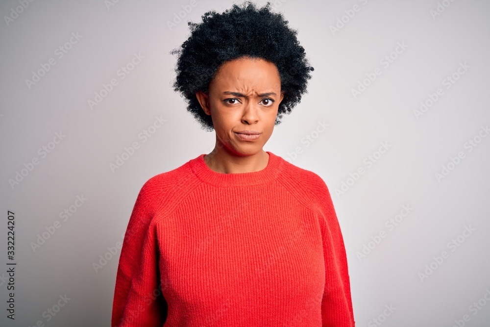 Young beautiful African American afro woman with curly hair wearing red casual sweater skeptic and nervous, frowning upset because of problem. Negative person. Young beautiful African American afro woman with curly hair wearing red casual sweater skeptic and nervous, frowning upset because of problem. Negative person.