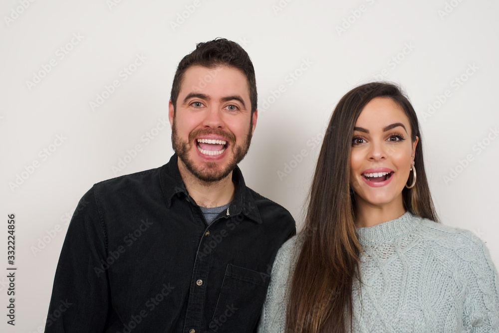 Emotive young beautiful woman wears casual clothes, happy and excited to celebrate anniversary. Happy young woman has good mood stands against gray wall. Emotive young beautiful woman wears casual clothes, happy and excited to celebrate anniversary. Happy young woman has good mood stands against gray wall.