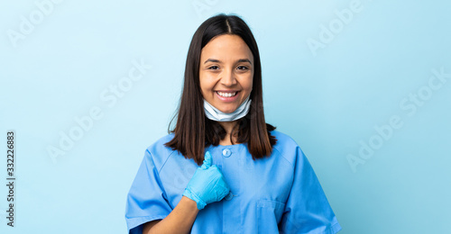 Foto Surgeon woman over isolated blue background with surprise facial expression