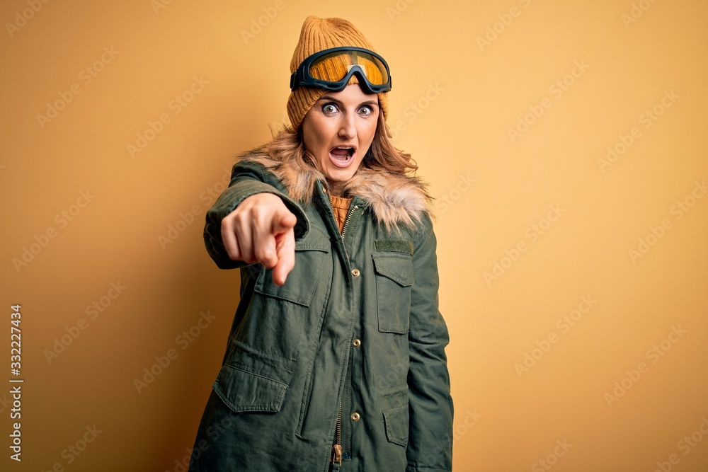 Middle age beautiful blonde skier woman wearing snow sportwear and ski goggles pointing displeased and frustrated to the camera, angry and furious with you Middle age beautiful blonde skier woman wearing snow sportwear and ski goggles pointing displeased and frustrated to the camera, angry and furious with you