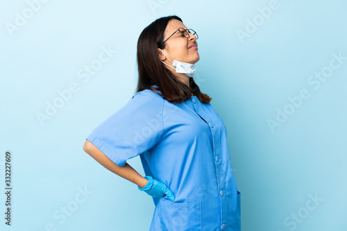 Billede på lærred Surgeon woman over isolated blue background suffering from backache for having m