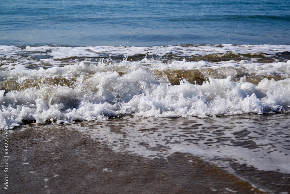 Waves with foam close up on a tropical sandy beach on a sunset. Copy space for background Waves with foam close up on a tropical sandy beach on a sunset. Copy space for background