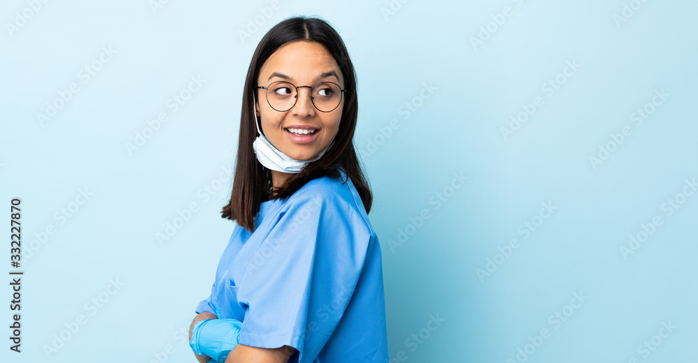 Surgeon woman over isolated blue background with arms crossed and happy Surgeon woman over isolated blue background with arms crossed and happy