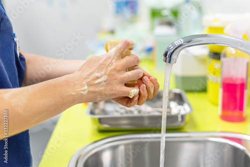 Coronavirus prevention. Close up unrecognizable nurse washing her hands after treat a patient with Covid-19 infection. Medical sanitizing procedure .