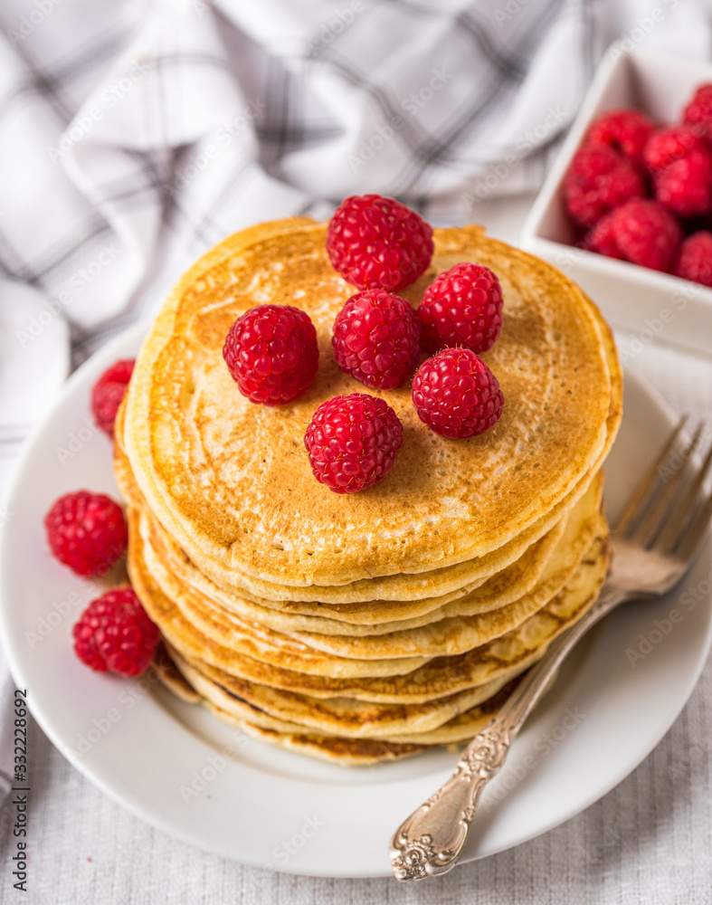 Sweet homemade pancakes with raspberries and on white plate. Sweet homemade pancakes with raspberries and on white plate.