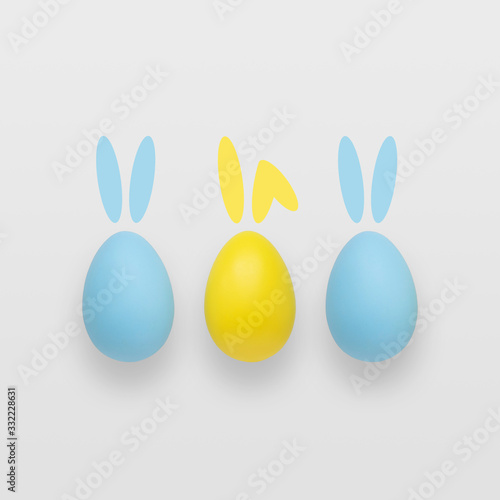 Blue and yellow easter eggs on a gradient gray background.