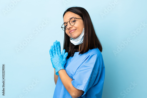 Surgeon woman over isolated blue background scheming something