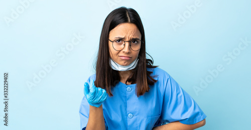 Fotografie Surgeon woman over isolated blue background making Italian gesture