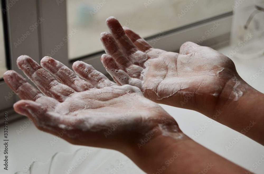 Fototapeta premium baby hands with ankles up washed against a white window