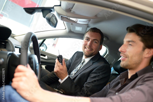 Advice in the car dealership - seller and young man selling a new car © industrieblick