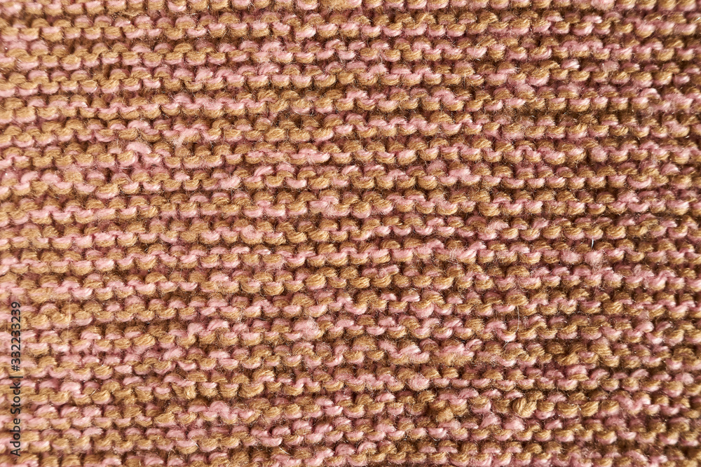 Knitted texture of beige and pink color with macro shawl technique Knitted texture of beige and pink color with macro shawl technique