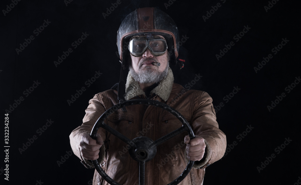 studio portrait of an old racing driver with a cigar on a black background studio portrait of an old racing driver with a cigar on a black background