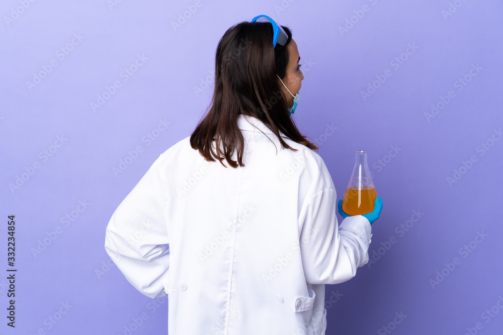 Scientist woman investigating a vaccine to cure coronavirus disease in back position and looking side Scientist woman investigating a vaccine to cure coronavirus disease in back position and looking side