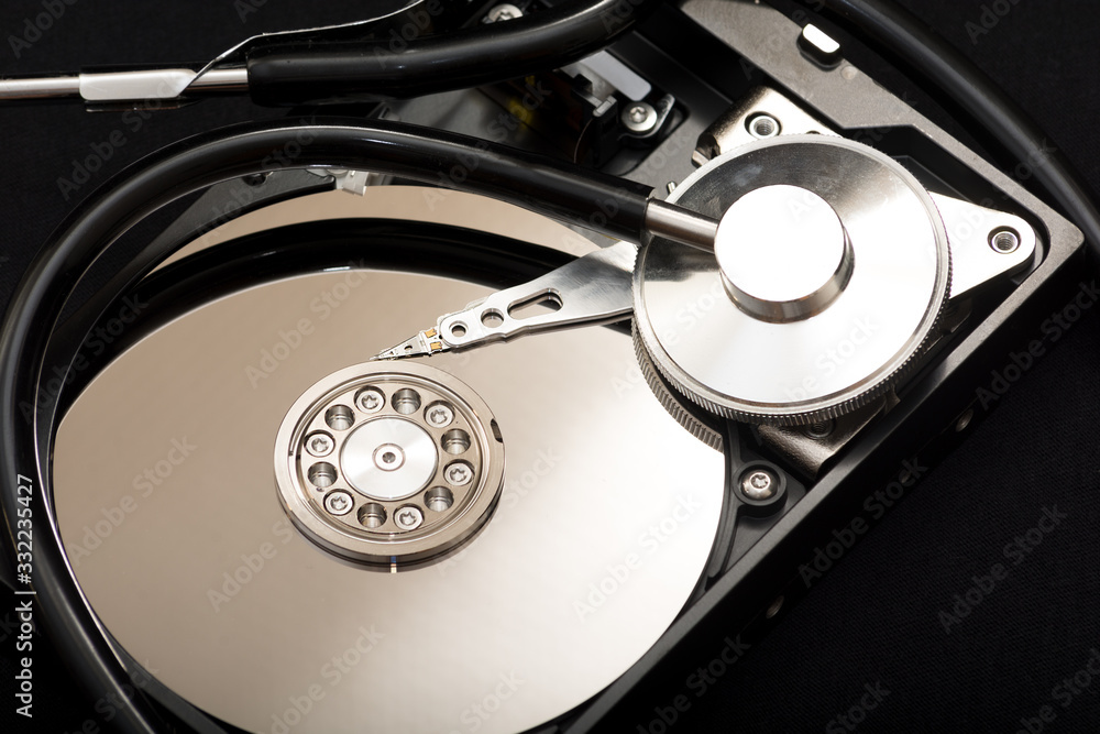 Internal parts of the hard drive. HDD. Modern technologies. Computer repair. Data storage concept. Black background. A stethoscope near the hard drive. Diagnostics concept. Recover lost data.