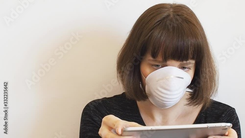 Caucasian young woman wearing face mask during Coronavirus pandemic quarantine using tablet