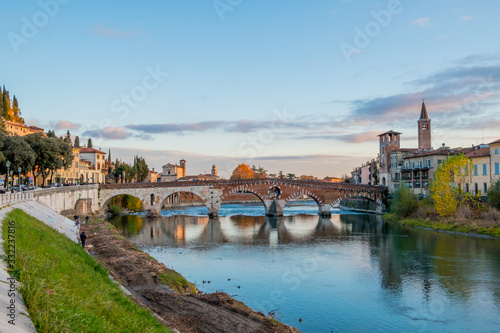 View at sunset of the ancient Roman arch Stone Bridge (Ponte Pietra) over the Adige River in Verona, Italy / APRIL 21, 2019