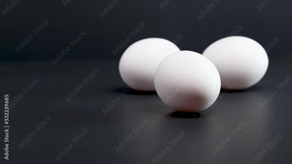 egg rolling into other eggs isolated on studio black background egg rolling into other eggs isolated on studio black background