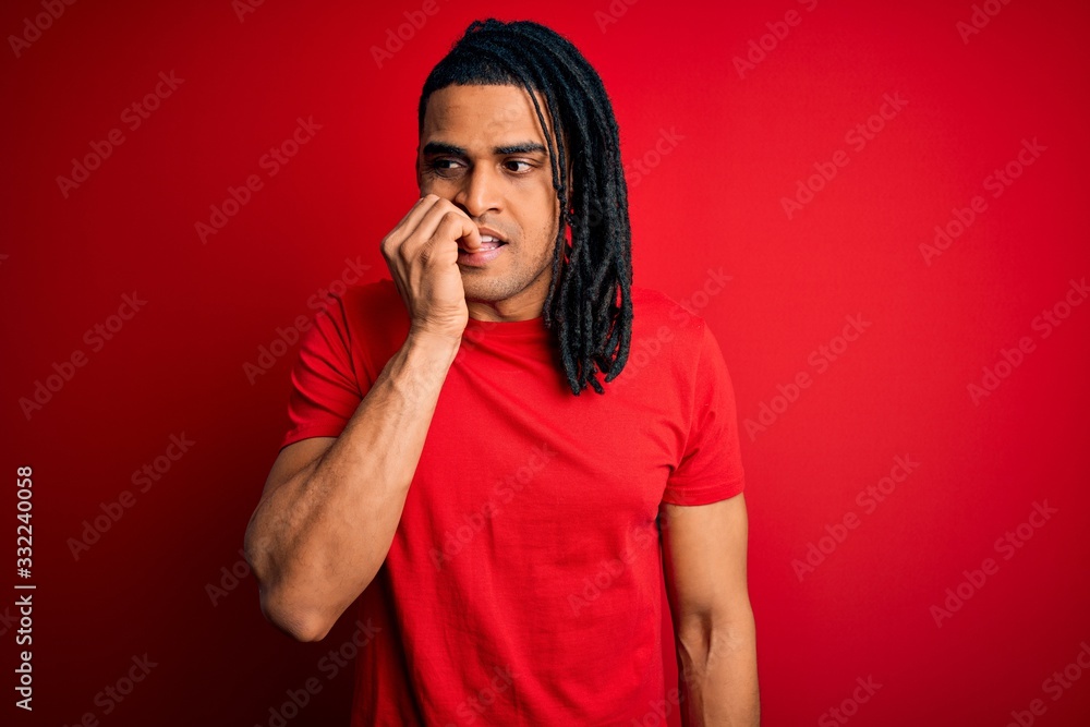 Young handsome african american afro man with dreadlocks wearing red casual t-shirt looking stressed and nervous with hands on mouth biting nails. Anxiety problem. Young handsome african american afro man with dreadlocks wearing red casual t-shirt looking stressed and nervous with hands on mouth biting nails. Anxiety problem.